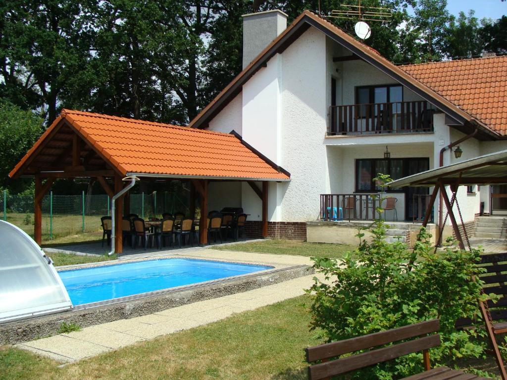 uma casa e uma piscina em frente a uma casa em Apartmány Dívčice em Dívčice