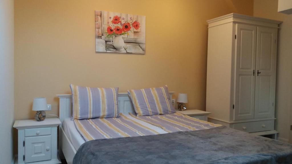 1 dormitorio con 1 cama, armario y flores en Enjoy Apartment, en Timisoara