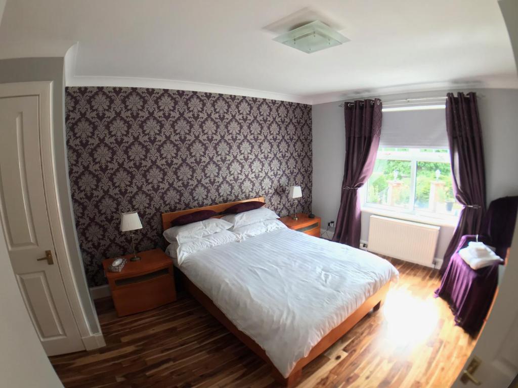 a bedroom with a bed and a window at The Neuk in Uphall