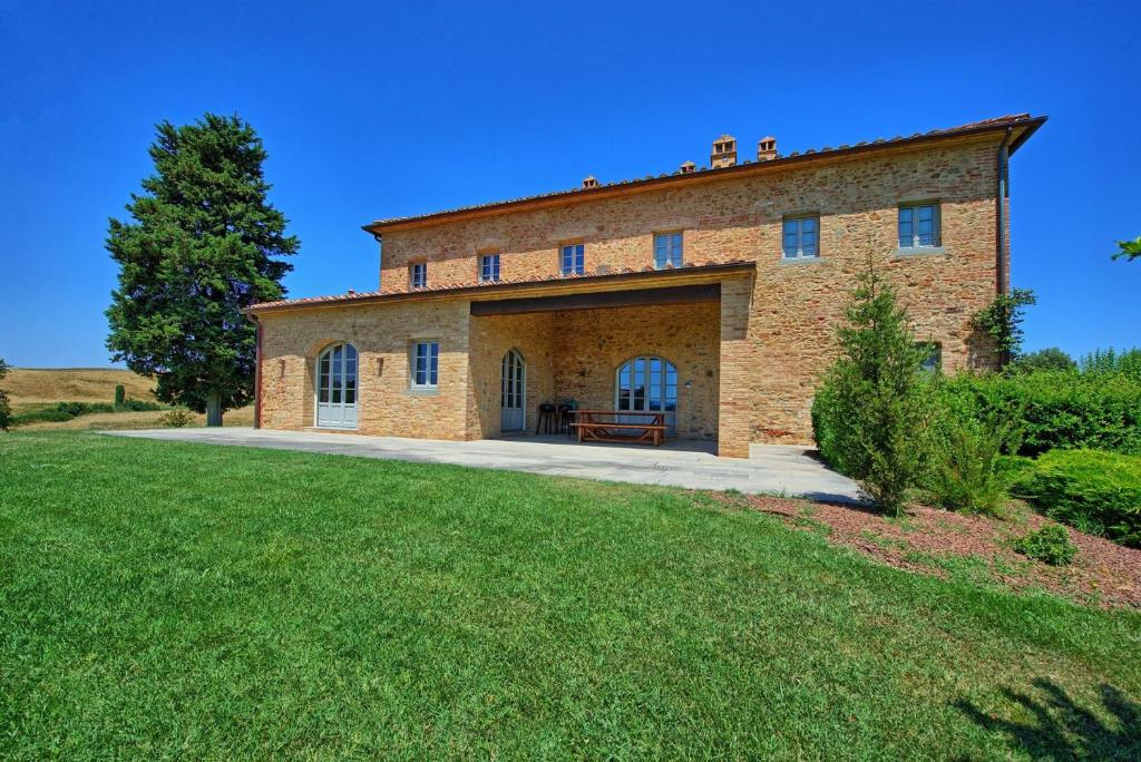 a large brick house with a large yard at La Valle in Castelfalfi