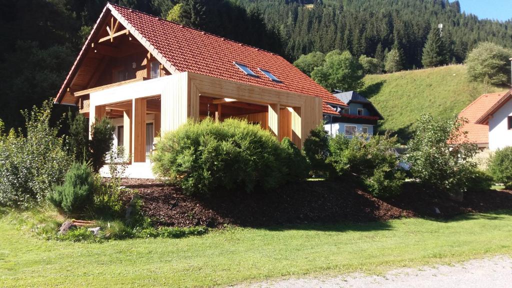 una pequeña casa con techo rojo en una colina en Alpin Haus Turrach en Turracher Hohe