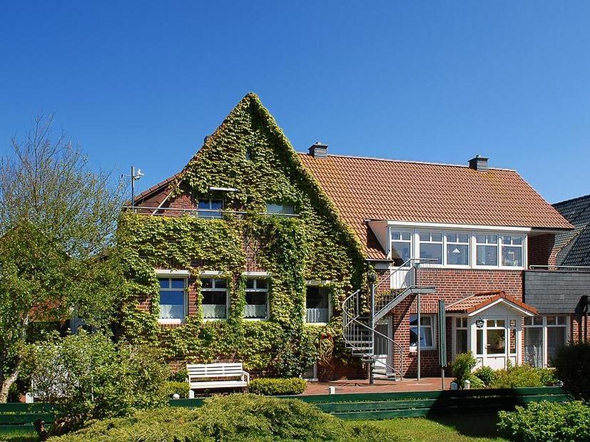 ein Haus mit Efeu, der nebenbei wächst in der Unterkunft Haus Kiebitznuest - Langeoog in Langeoog