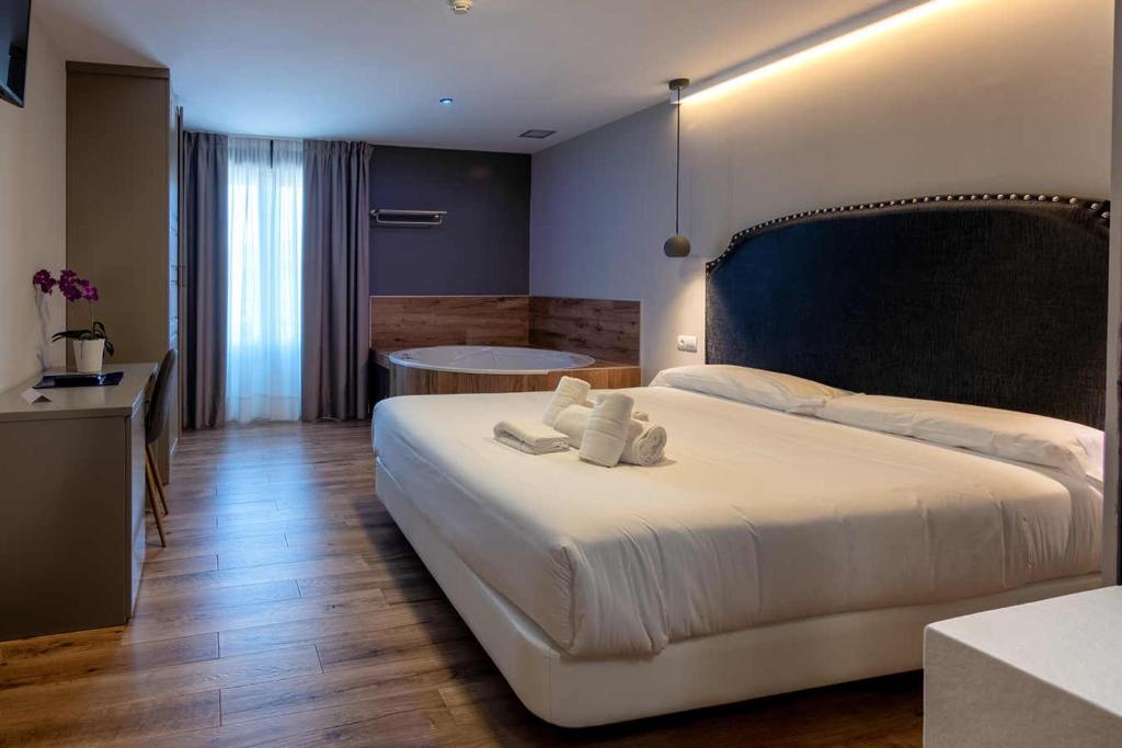 a bedroom with a large bed and a bath tub at Hotel Gastronómico Torre de Galizano in Galizano
