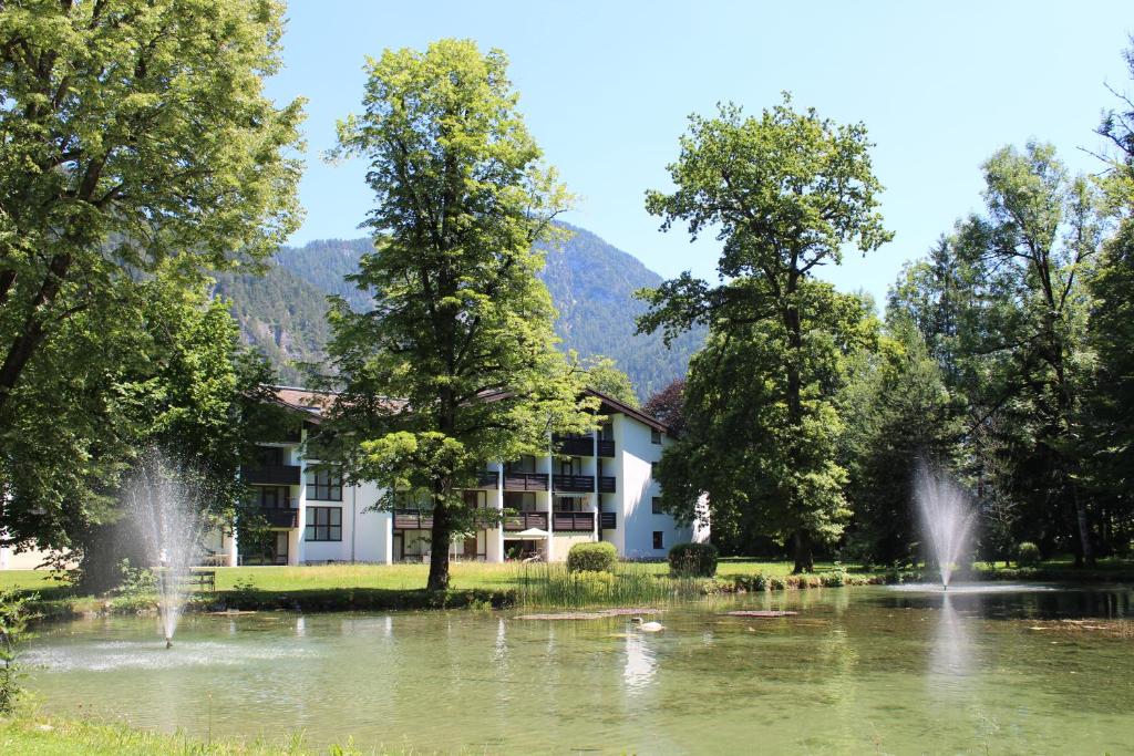 a building in front of a lake with a fountain at Appartement 21 in Sankt Martin bei Lofer