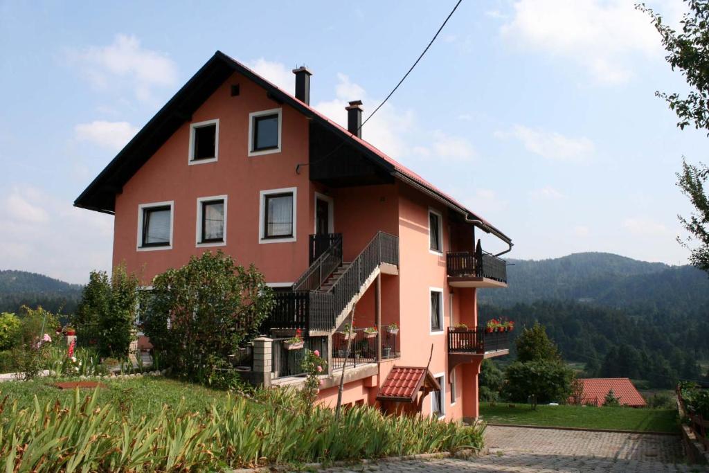 a house on a hill with mountains in the background at Vila Zelena oaza in Lokve