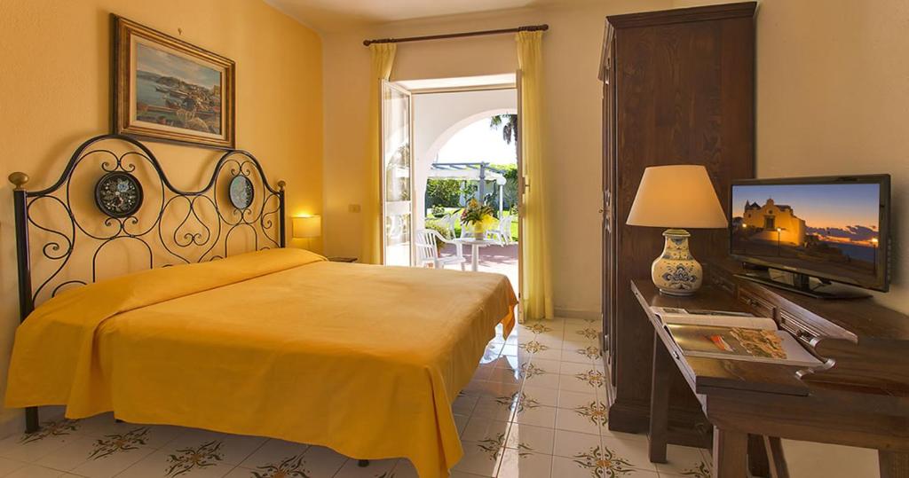 a bedroom with a bed and a television and a table at Hotel Belsole in Ischia