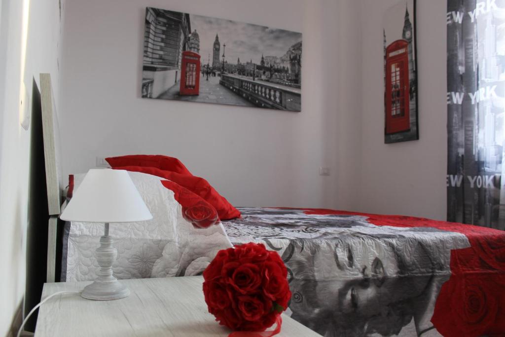um quarto com uma cama com uma rosa vermelha sobre uma mesa em Pisa Apartment Tower em Pisa