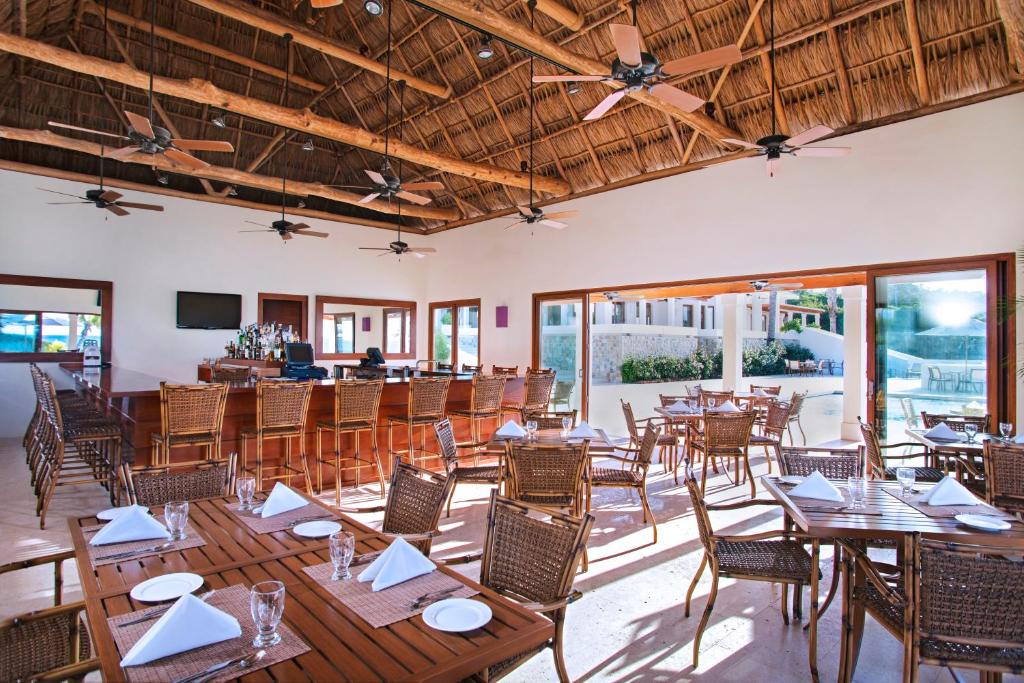 una sala da pranzo con tavoli e sedie in legno di Las Verandas Hotel & Villas a First Bight