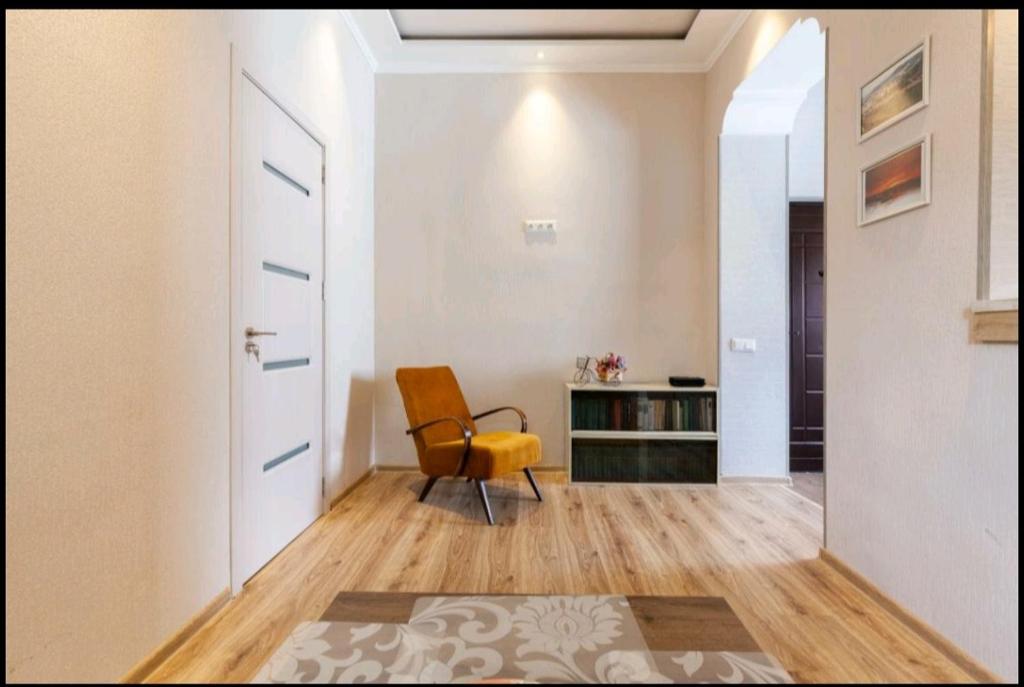 a living room with a yellow chair and a desk at Your apartment in Old Tbilisi-Ortachala in Tbilisi City