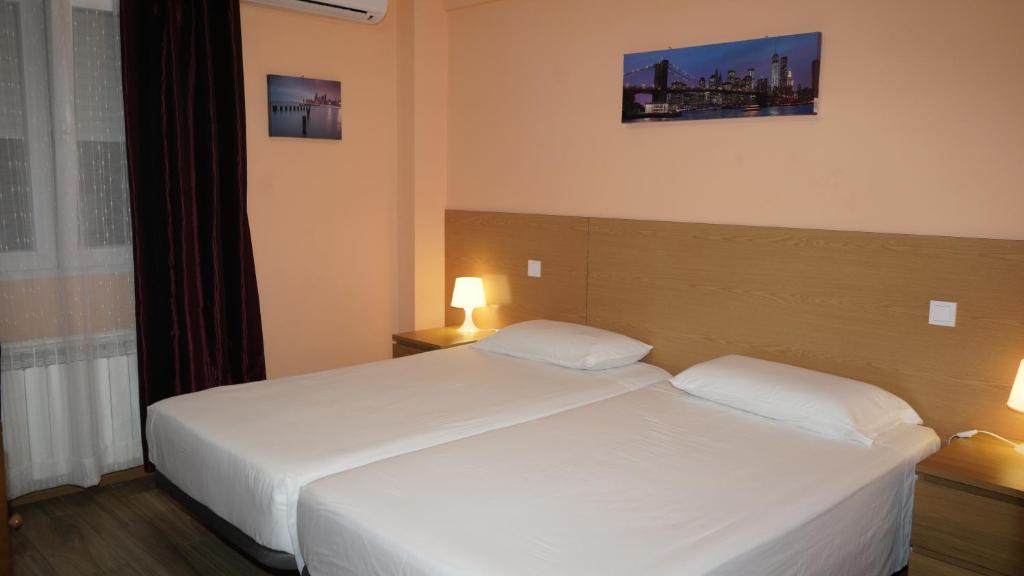 - une chambre avec un grand lit blanc et 2 oreillers dans l'établissement Hostal La Pared, à Torres de la Alameda