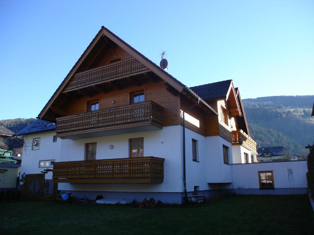 a large wooden house with a balcony on a hill at Appartementhaus Erasim in Schladming