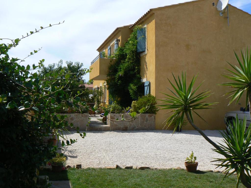 a house with a gravel yard next to a building at Villa les Pensées La Londe in La Londe-les-Maures