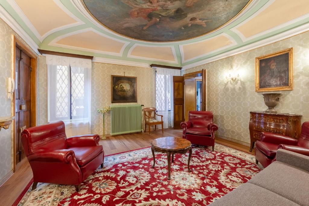 a living room with red chairs and a ceiling at Hotel Mezzo Pozzo in Venice