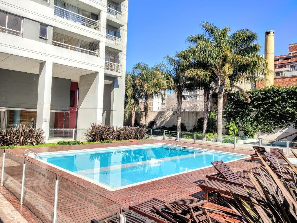 una piscina con sillas junto a un edificio en Moderno Loft en Palermo Queen. en Buenos Aires