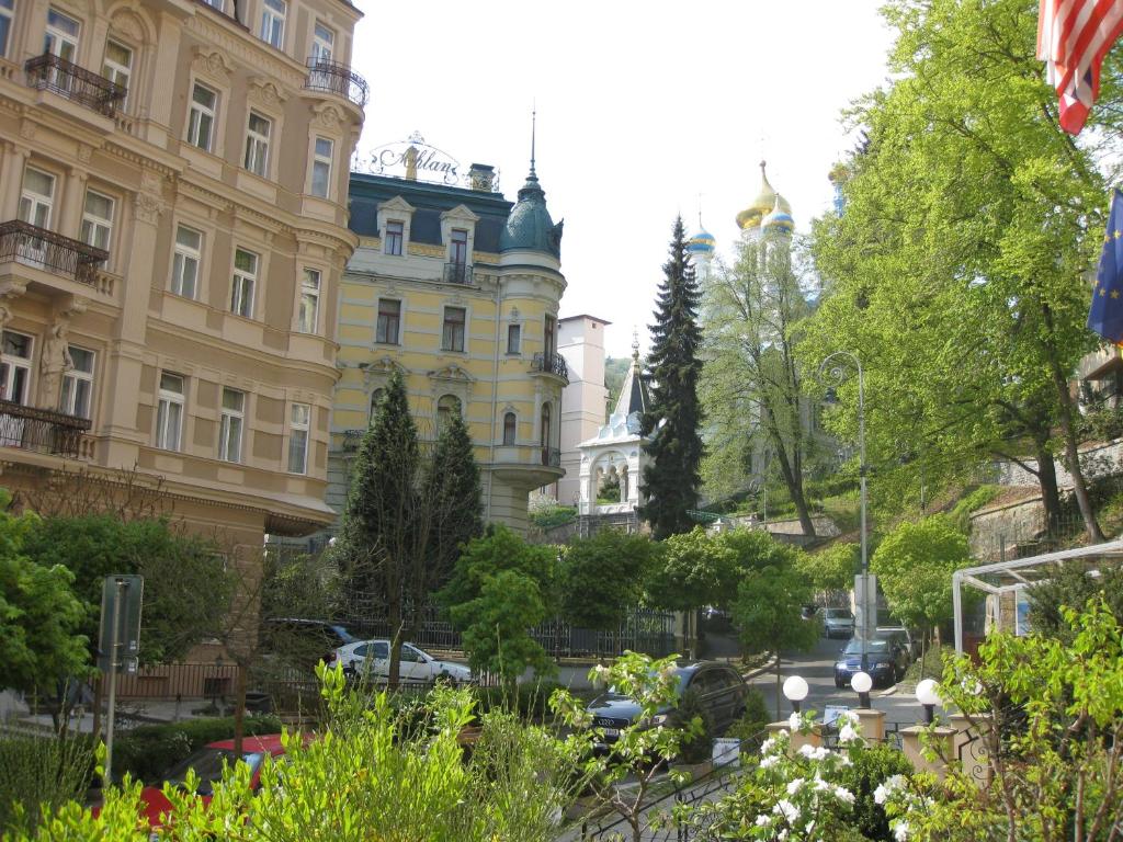 un edificio con una bandera delante de él en Apartment Sadova en Karlovy Vary