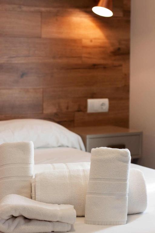 a bedroom with white towels on a bed at Hotel Gastronómico Torre de Galizano in Galizano