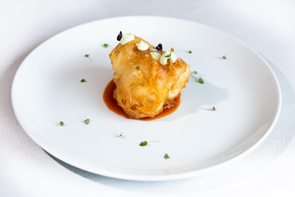 a white plate with a piece of food on it at Hotel Gastronómico Torre de Galizano in Galizano
