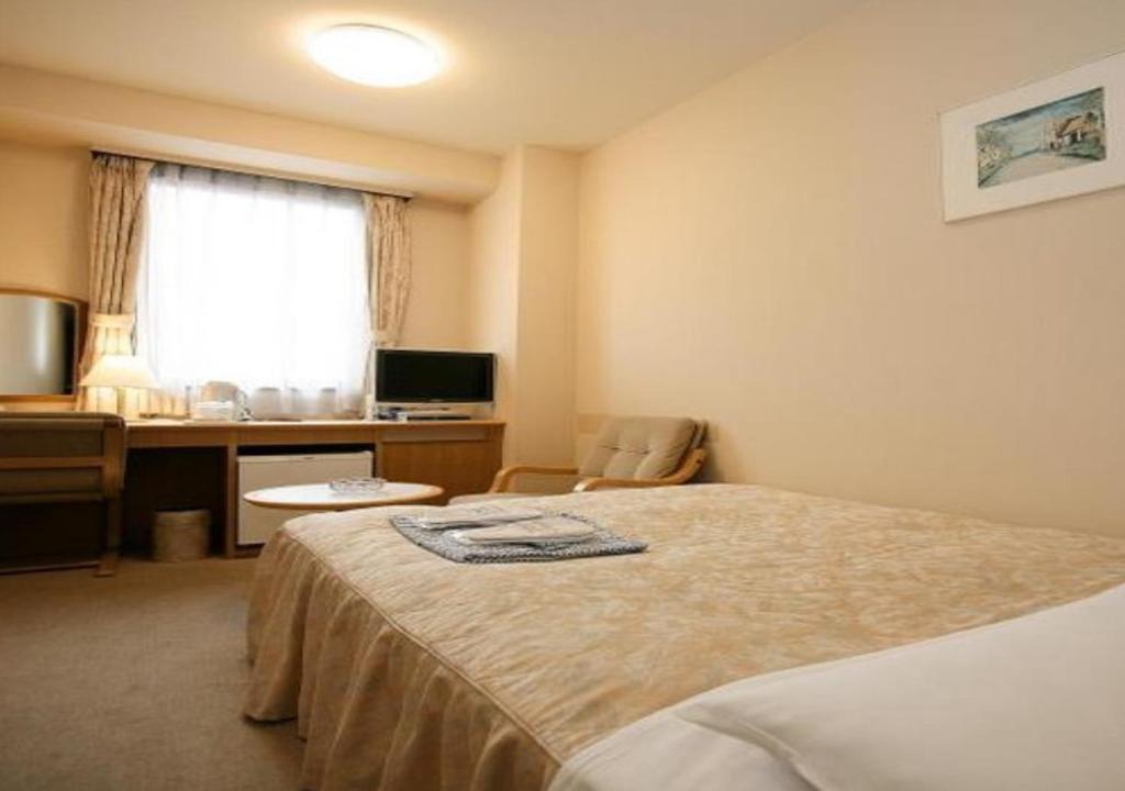 una camera d'albergo con letto e scrivania con computer di Narita U-City Hotel / Vacation STAY 42505 a Narita