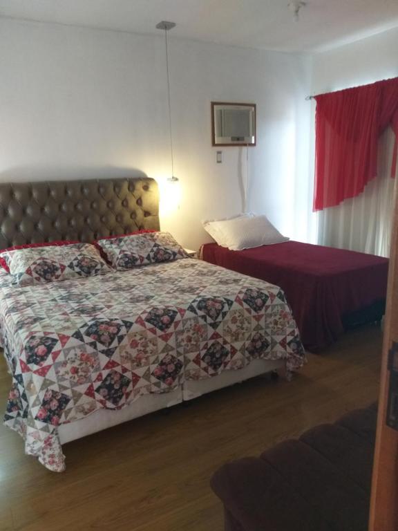 um quarto com uma cama com uma colcha em Pousada Domiciliar Agua Verde em Jaraguá do Sul