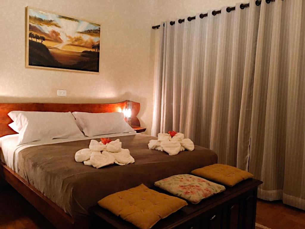 a bedroom with a bed with towels on it at Pousada Recanto das Marias in Santo Antônio do Pinhal