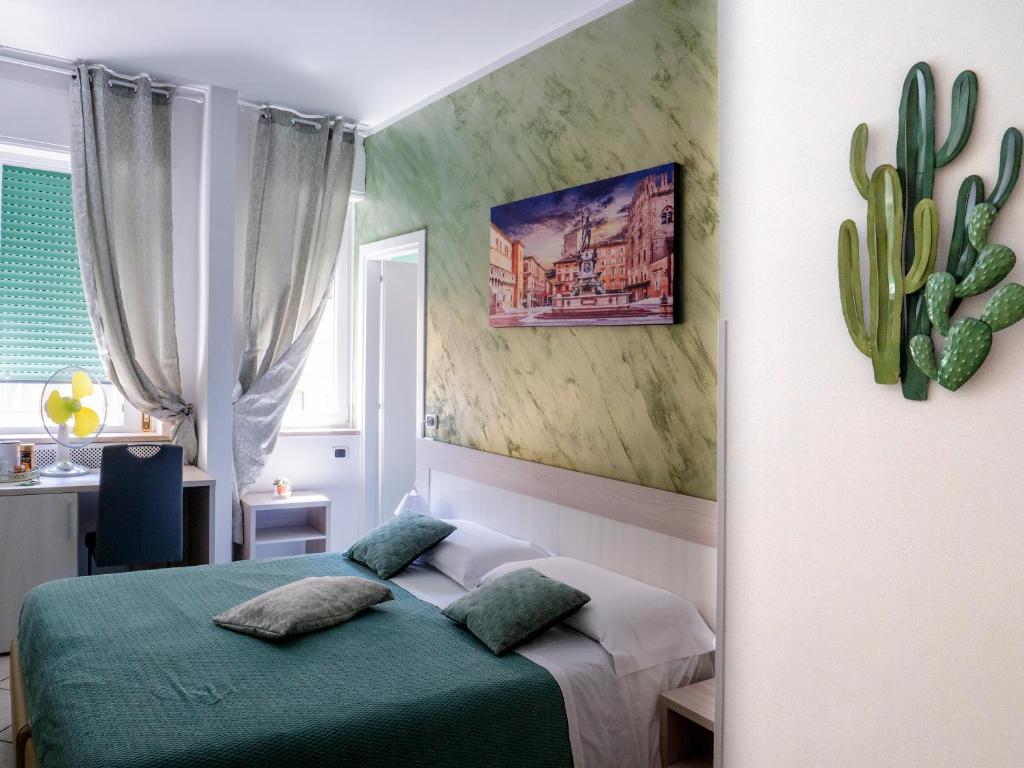 a bedroom with a green bed and a cactus at Albachiara Suite Rooms in Bologna