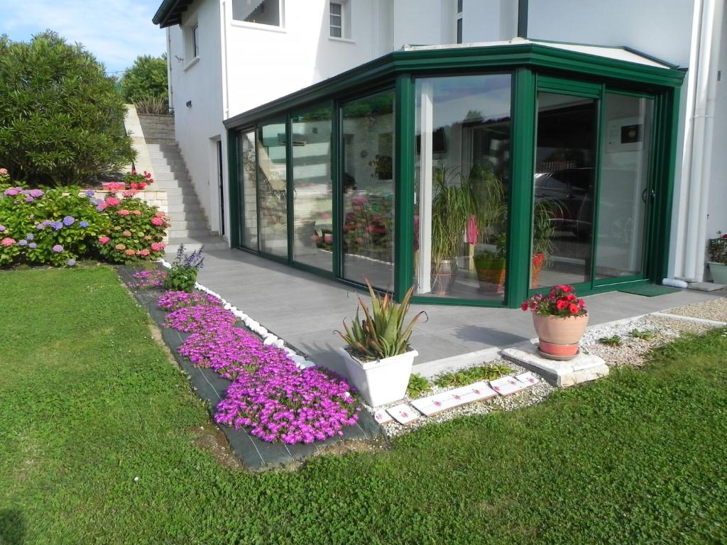 einen Garten mit lila Blumen in einem Gewächshaus in der Unterkunft gure xokoa in Urrugne