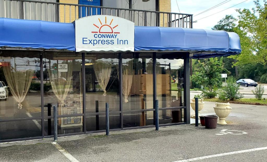 a store with a blue awning in front of a building at Conway Express Inn in Conway