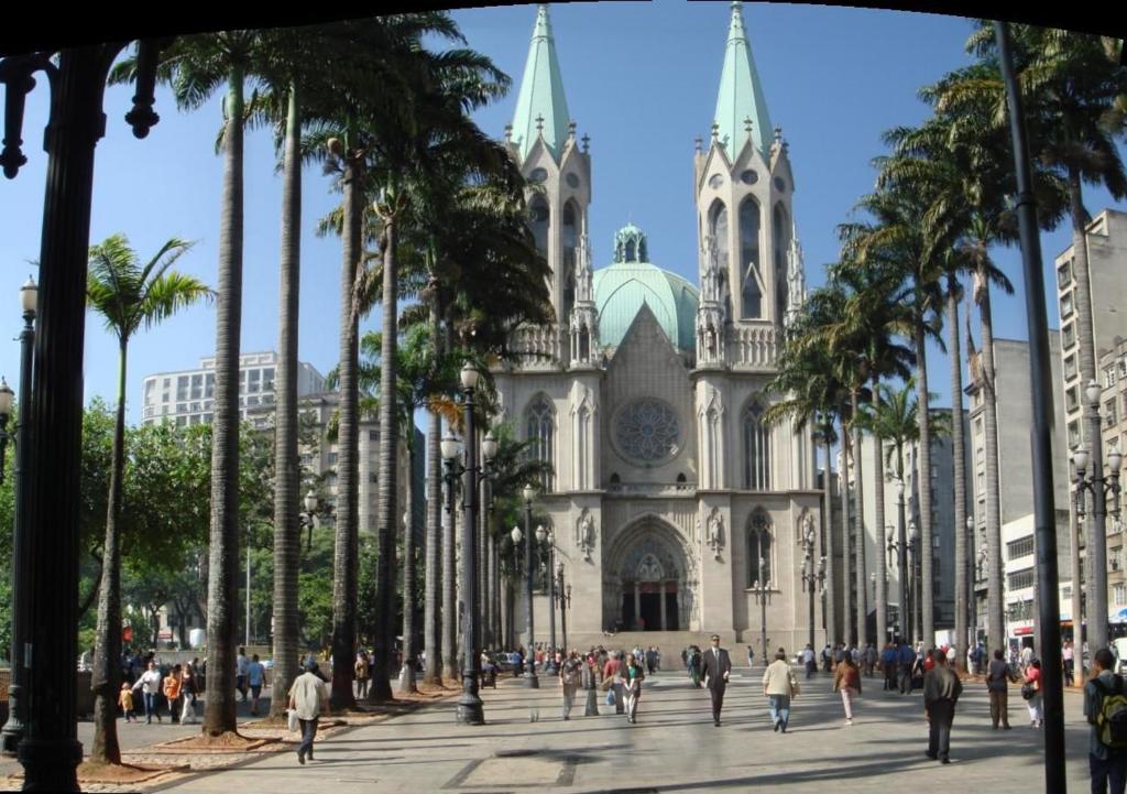 uma igreja com palmeiras em frente em hotel Economico da SE em São Paulo