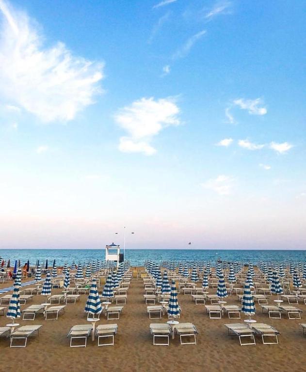 a bunch of lounge chairs on a beach at Residence El Patio in Lido di Jesolo