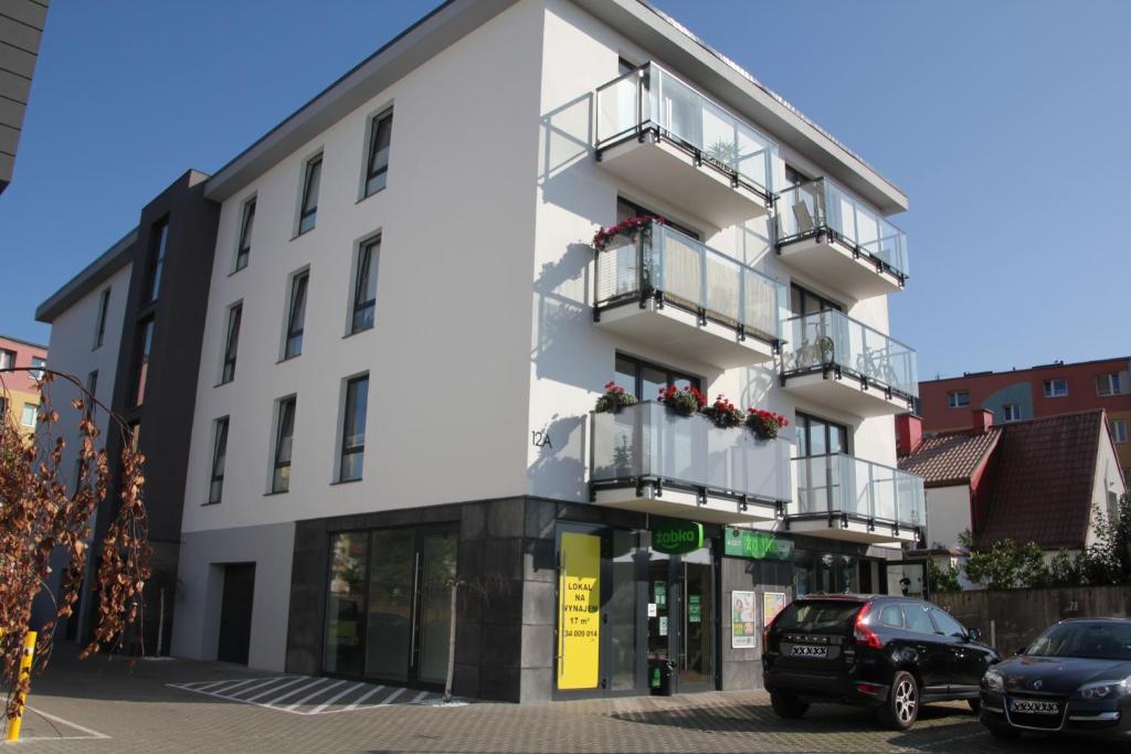 a white building with balconies on a street at Apartament Spacerowa in Wejherowo