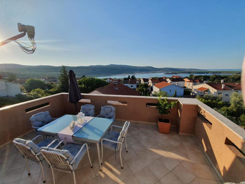 a patio with a table and chairs on a balcony at Allure Apartment in Kornić