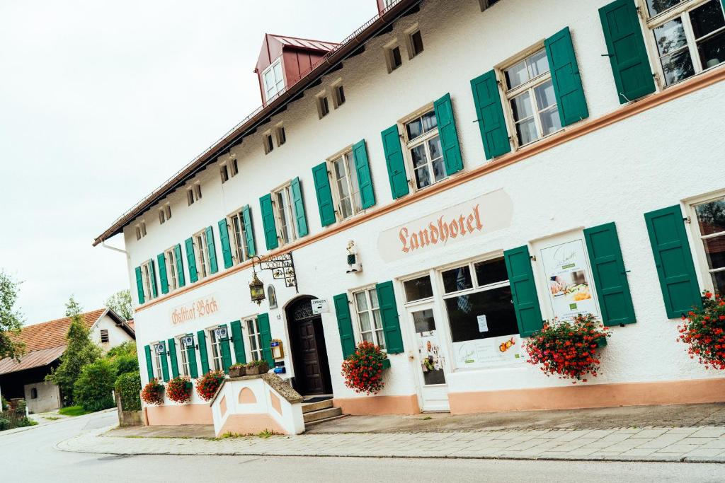 a building with green shutters on a street at Landgasthof Böck in Unterbrunn
