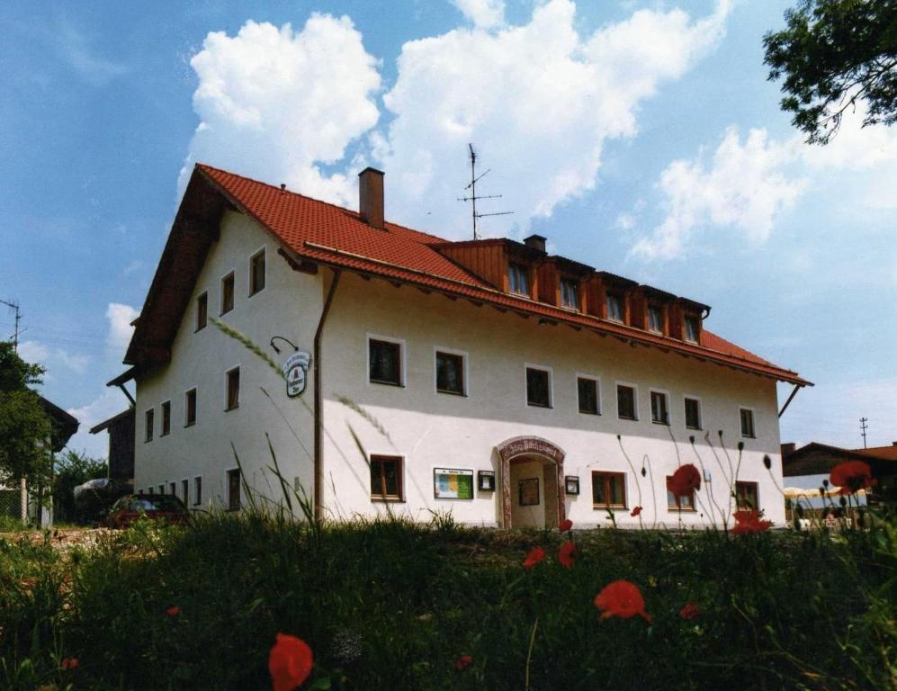 ein großes weißes Haus mit rotem Dach in der Unterkunft Gasthof zum Kirchenwirt in Kirchdorf am Inn