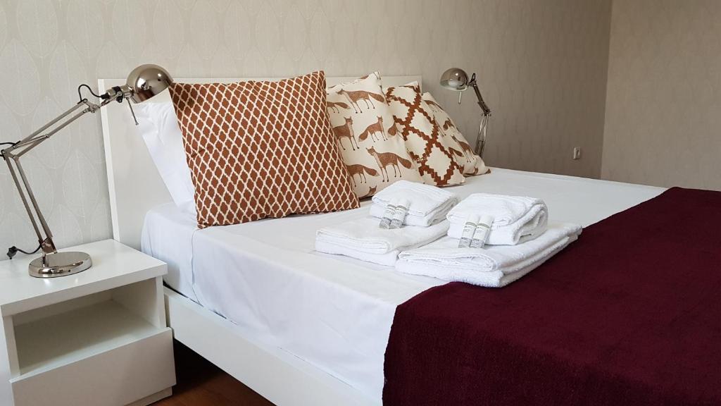 a white bed with towels and a lamp on it at Bragas Studios in Porto