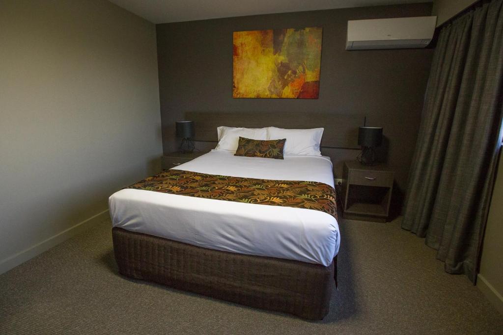 Postel nebo postele na pokoji v ubytování Gladstone Reef Hotel Motel