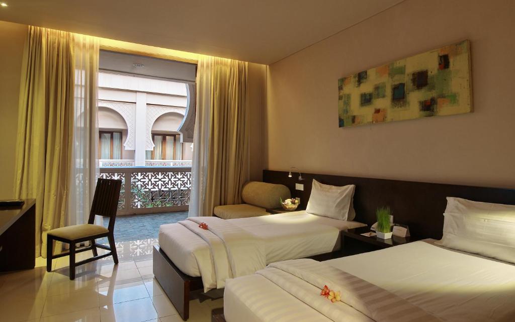 um quarto de hotel com duas camas e uma janela em The Pade Hotel em Banda Aceh