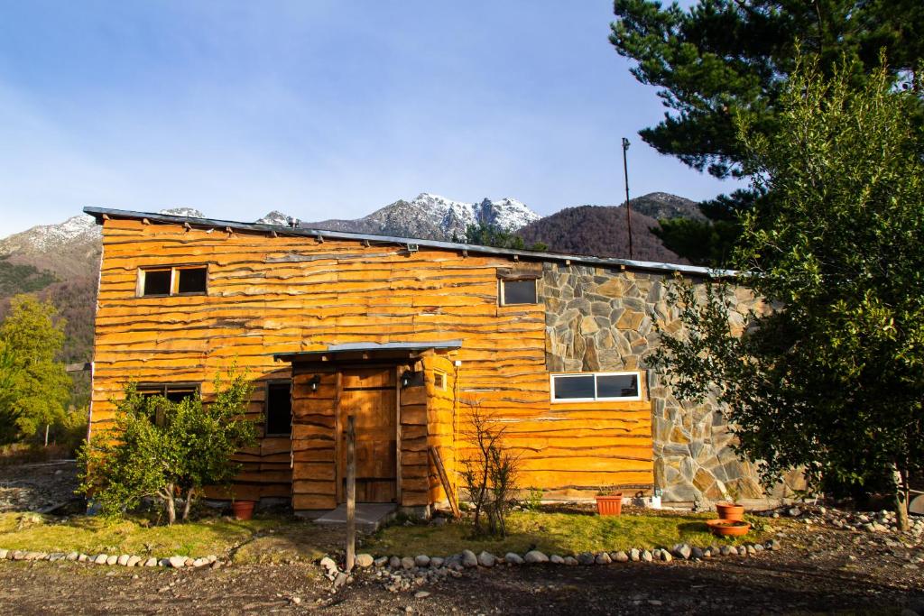 una cabaña de madera con una puerta delante en Rincon del Montañes en Antuco