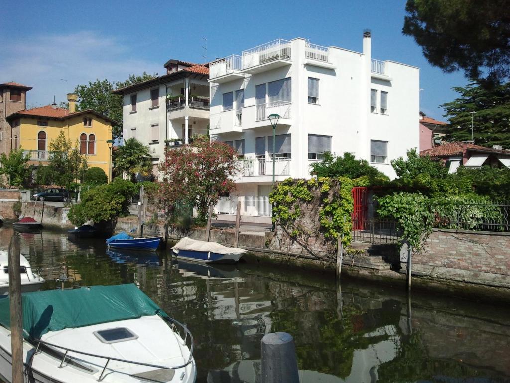 a white building next to a river with boats in it at Villa Venice Movie in Venice-Lido