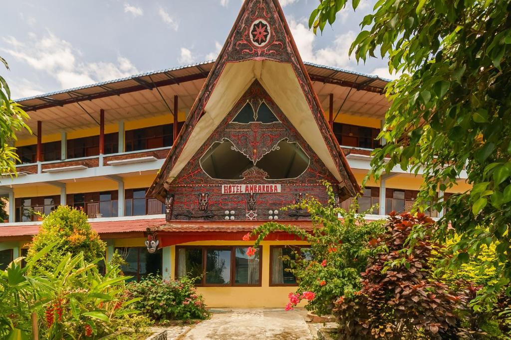 ein Gebäude mit einem dreieckigen Dach mit einem Schild darauf in der Unterkunft RedDoorz @ Tuktuk Danau Toba in Tuk Tuk