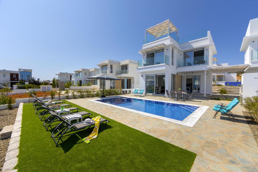 een villa met een zwembad en lawnitures bij Protaras Lifestyle Villa Mylos 9 in Protaras