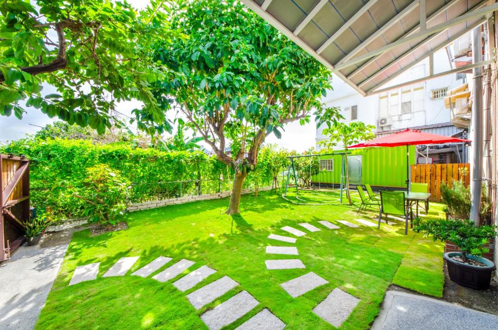 a garden with a grassy yard with a tree at Chi's House B&B in Taitung City