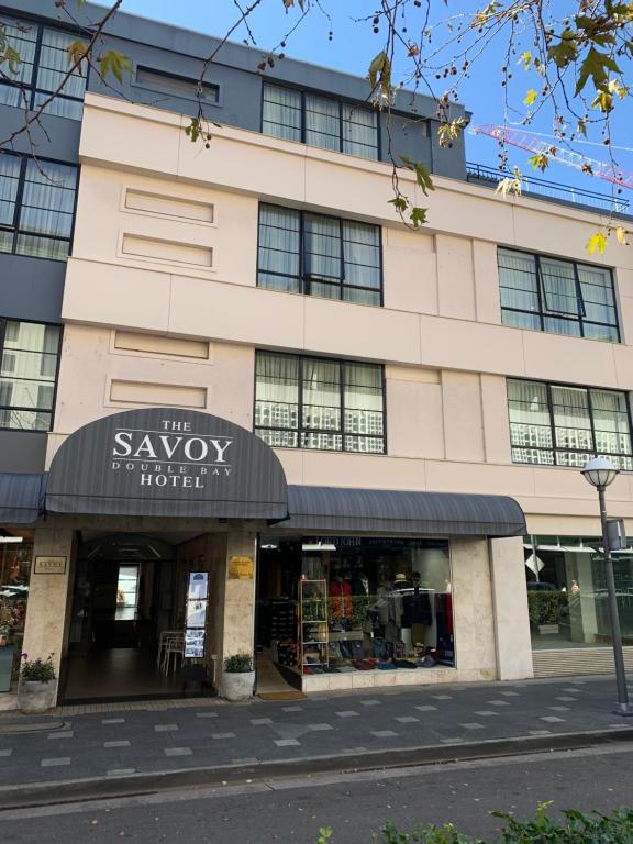 a building with a sign for the savoy hotel at Savoy Double Bay Hotel in Sydney