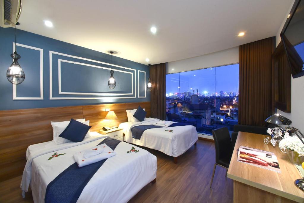 a hotel room with two beds and a view of the city at Hanoi Eternity Hotel in Hanoi