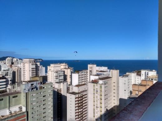 um horizonte da cidade com edifícios brancos e o oceano em Flat Praia Pitangueiras no Guarujá