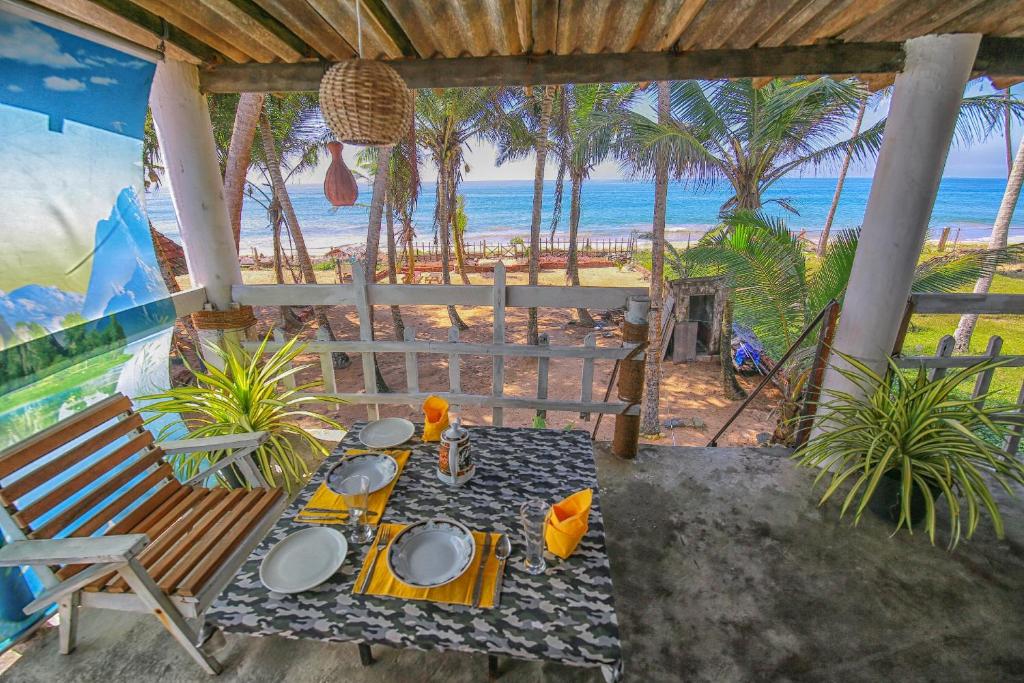 een patio met een tafel en uitzicht op het strand bij Ramya Ru Beach Home in Galle