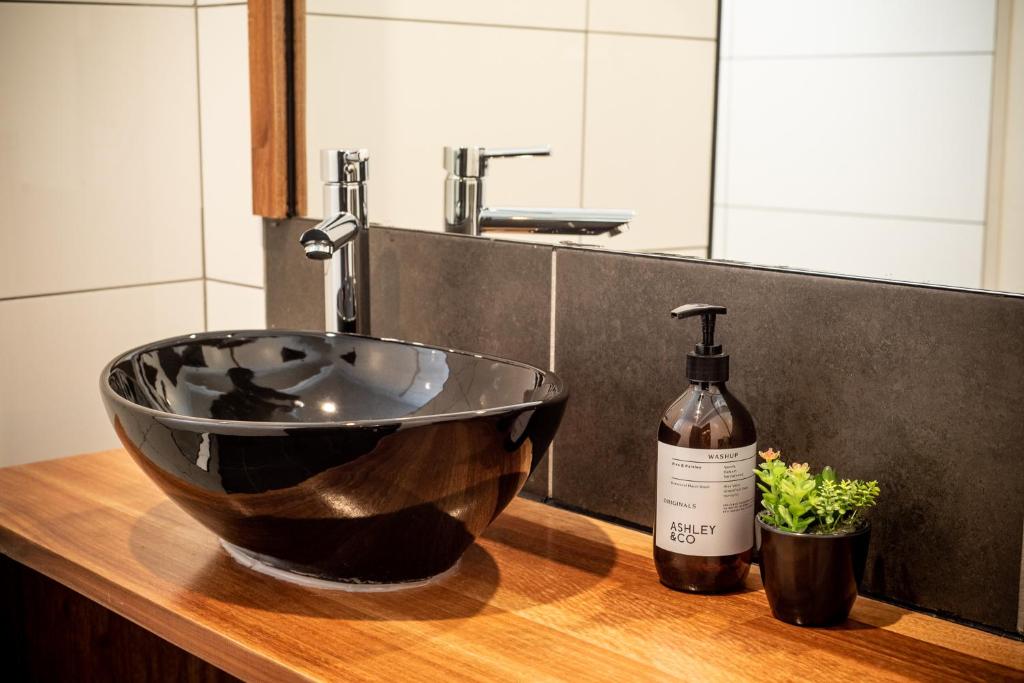 bagno con lavandino a ciotola e bottiglia di vino di Amber Lodge Mt Buller a Mount Buller