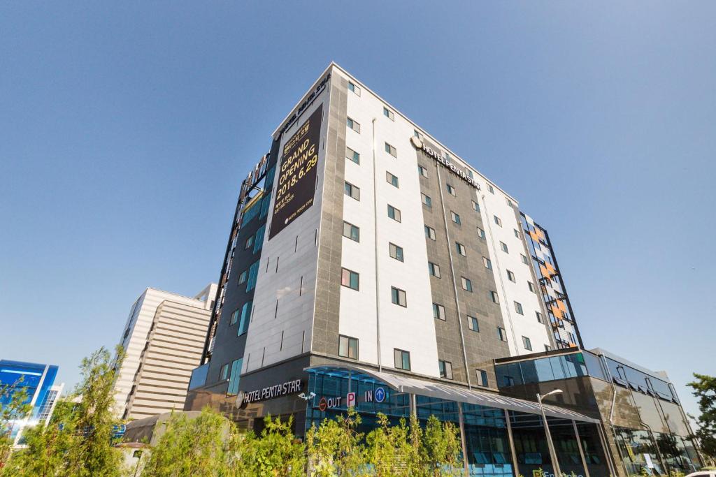 a tall white building with a sign on it at Gimpo Pentastar Hotel in Gimpo