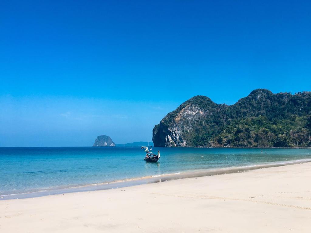 a boat in the water on a beach at Mookies Bungalows in Koh Mook