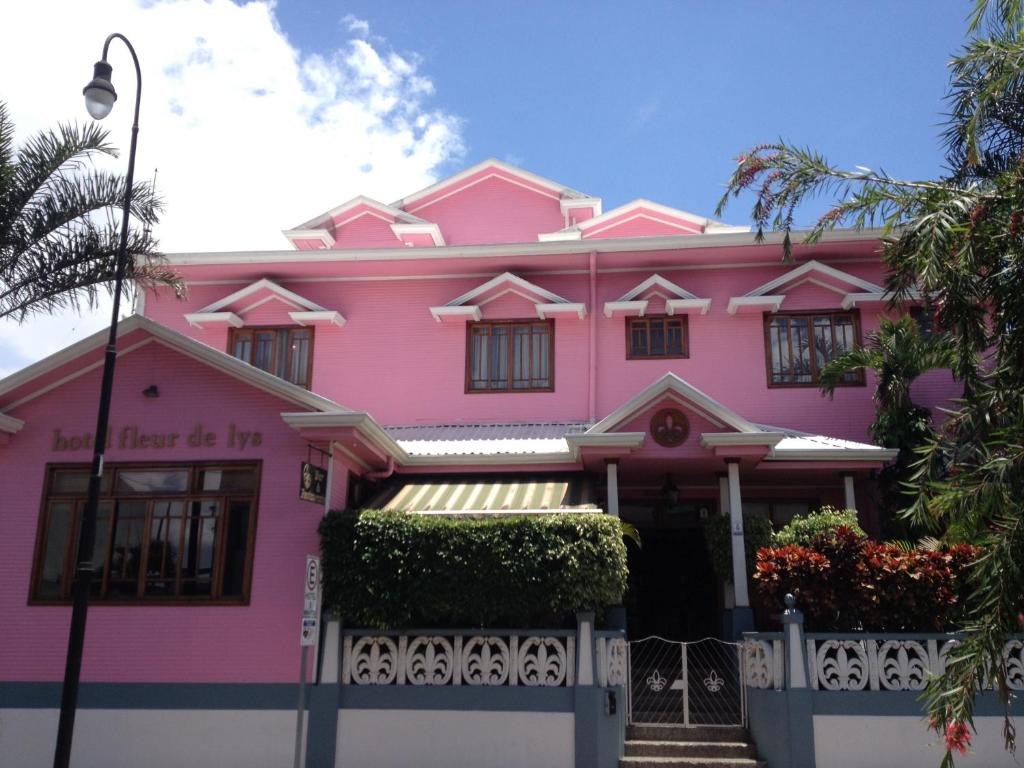 a pink house with a fence in front of it at Fleur de Lys in San José
