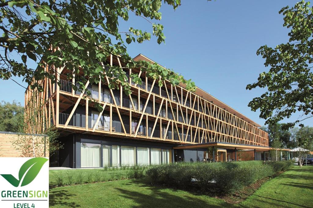 ein großes Gebäude mit einem Baum davor in der Unterkunft Hotel Bora HotSpaResort in Radolfzell am Bodensee